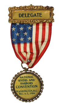A delegate's badge with a gold bar, a stars and stripes ribbon, and a gold medallion